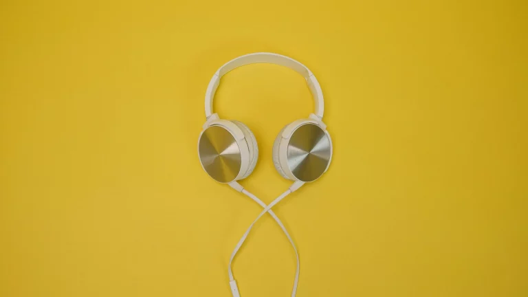 Kopfhörer auf gelbem Hintergrund als Symbol für Tinnitus, Hörwahrnehmung und moderne Behandlungsmethoden